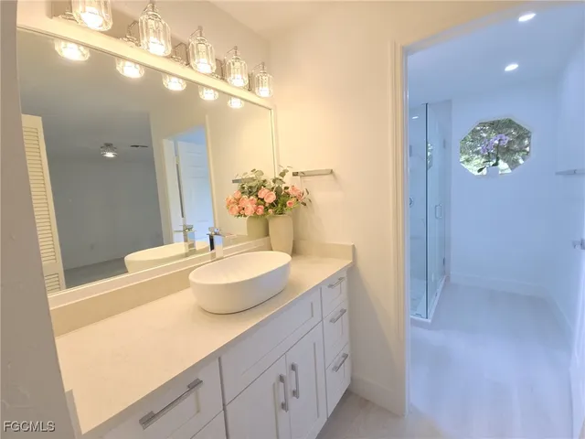 a bathroom with a sink mirror and bathtub