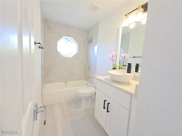 a bathroom with a tub sink and a mirror
