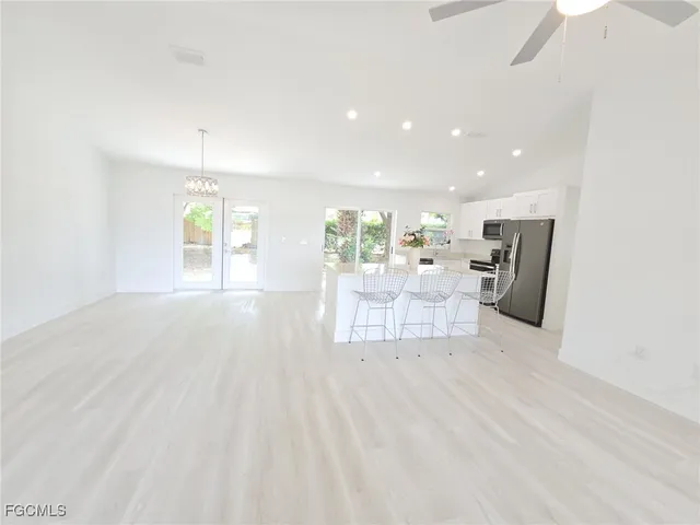 a room with stainless steel appliances kitchen island microwave and wooden floor