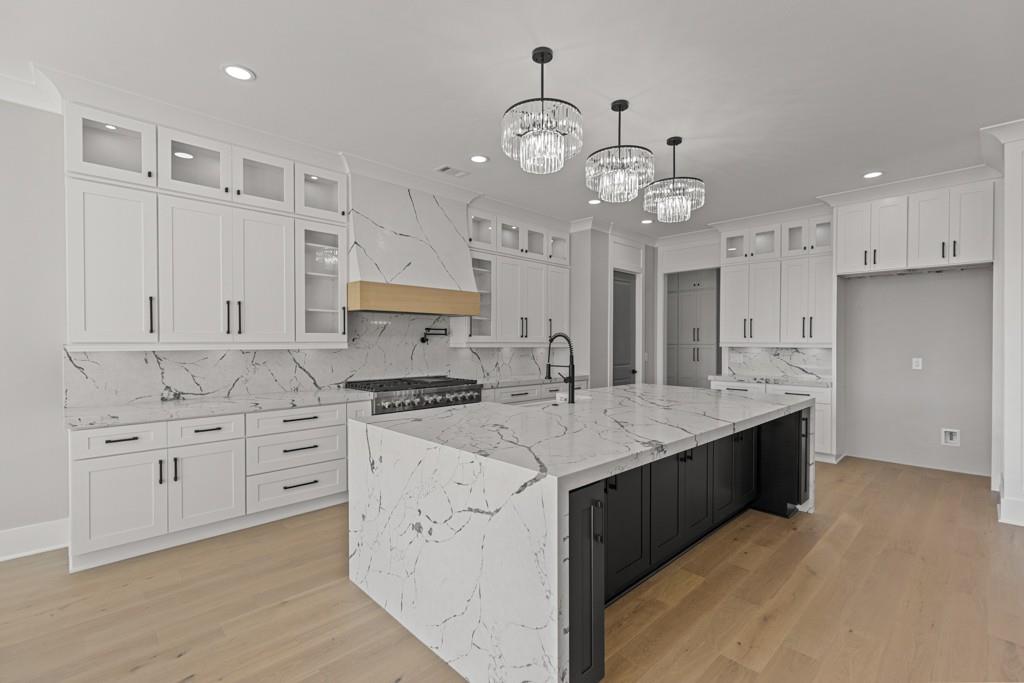 2739 South Waterworks Road Buford, GA 30518 - Photo 22 of 62 a kitchen with cabinets counter top space stainless steel appliances and a chandelier