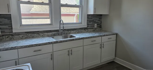 a kitchen with granite countertop cabinets sink and window