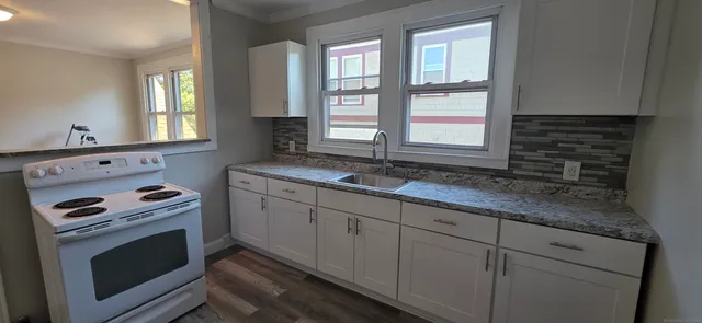 a kitchen that has a sink and a wooden floor