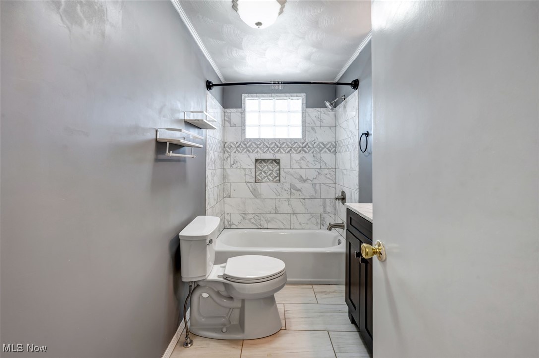 2879 St Johns Road Colliers, WV 26035 - Photo 16 of 42 Full bathroom with tile patterned floors, ornamental molding, tiled shower / bath combo, vanity, and toilet