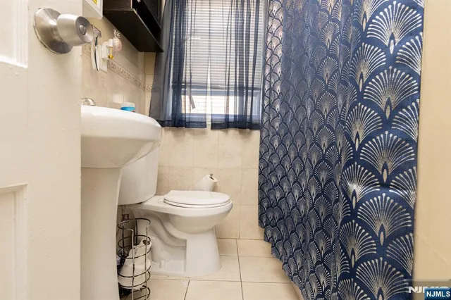 a bathroom with a toilet and a shower curtain