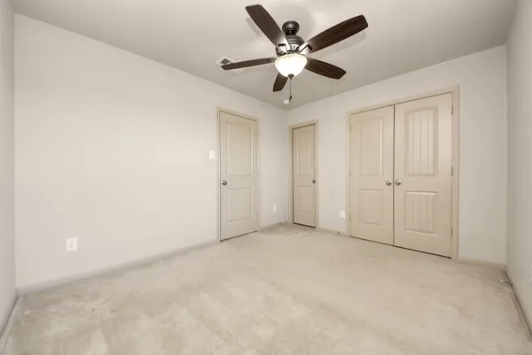 an empty room with a ceiling fan