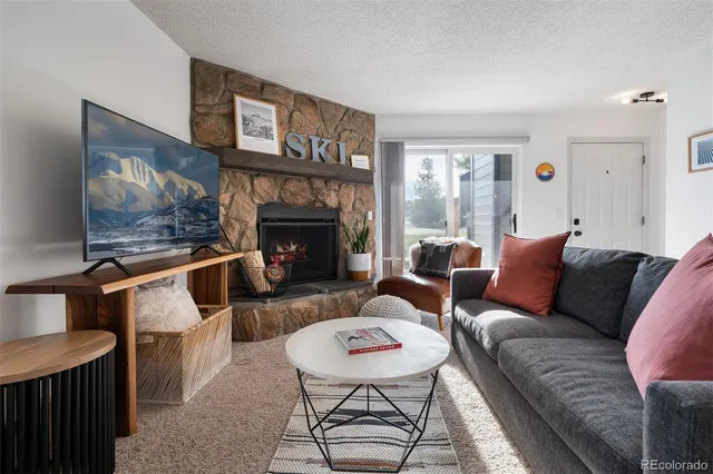 a living room with furniture a flat screen tv and a fireplace