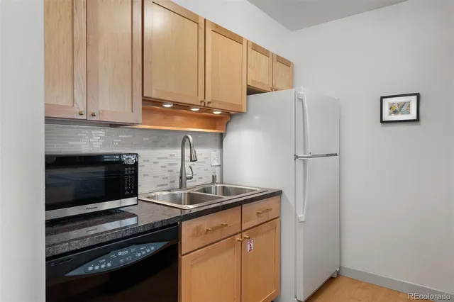 a kitchen with appliances a sink and cabinets