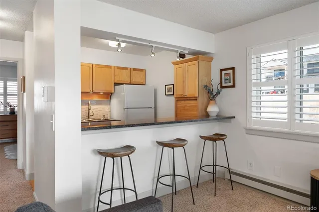 a kitchen with stainless steel appliances granite countertop a sink and a refrigerator