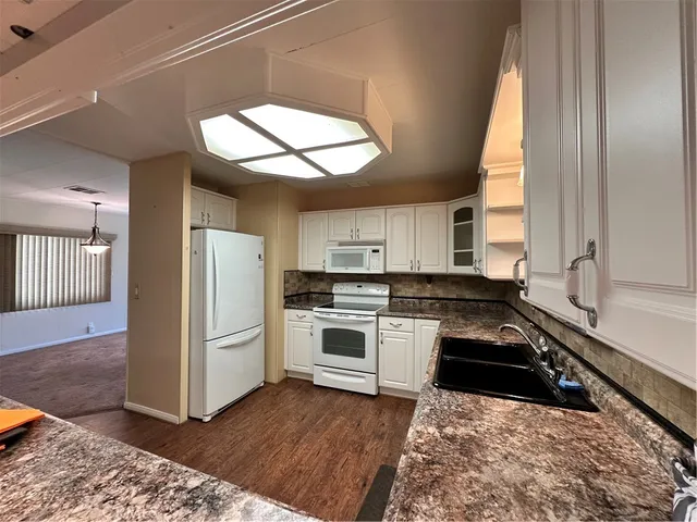 a kitchen with a refrigerator and a stove top oven