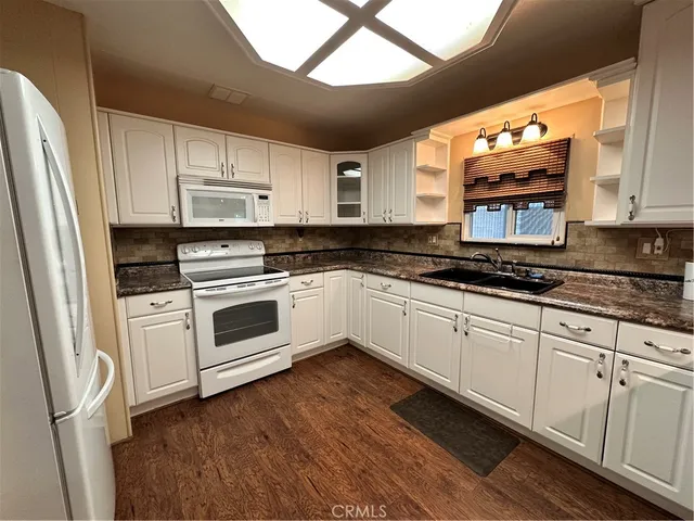 a kitchen with white cabinets and white appliances