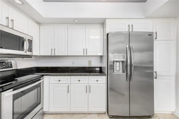 a kitchen with cabinets stainless steel appliances and a sink