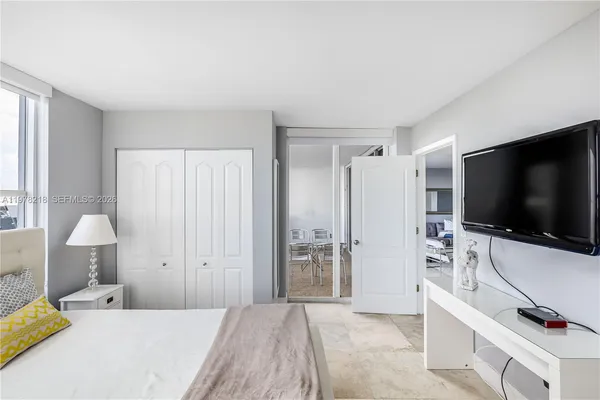 a bedroom with a bed and large windows