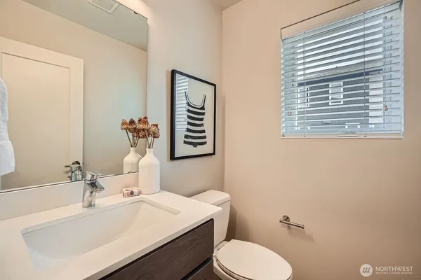 a bathroom with a sink vanity mirror and toilet