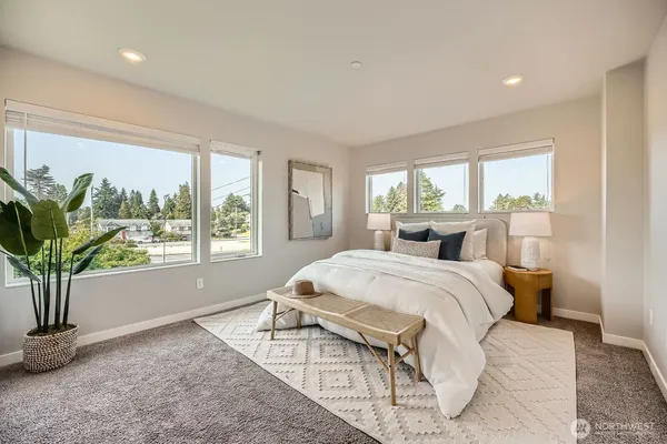 a spacious bedroom with a large bed and a potted plant