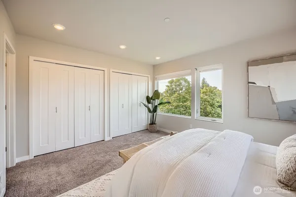 a spacious bedroom with a bed and a large window