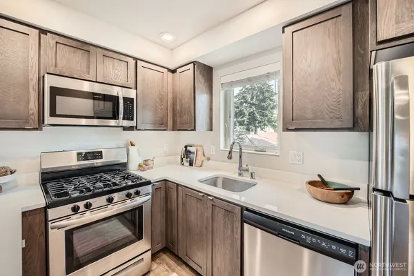 a kitchen with stainless steel appliances a stove sink microwave and cabinets