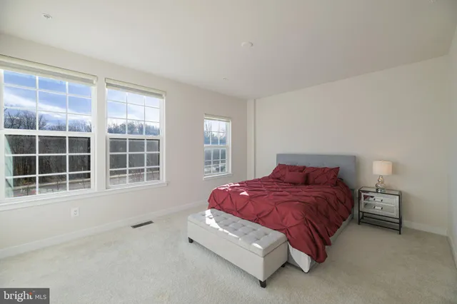 a bedroom with a bed and a large window
