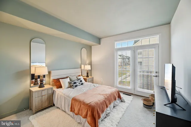 a bedroom with a bed and a flat tv screen on the dresser