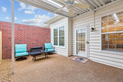 a backyard of a house with chairs and a table