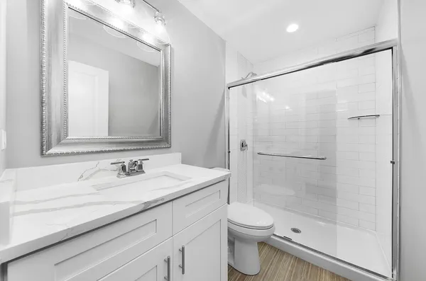 a bathroom with a sink a toilet and shower