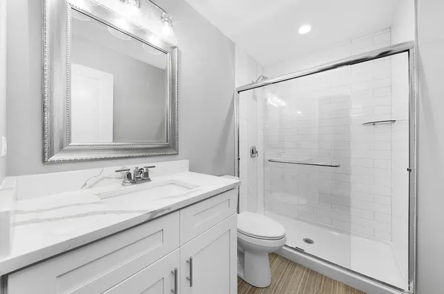 a bathroom with a sink a toilet and shower