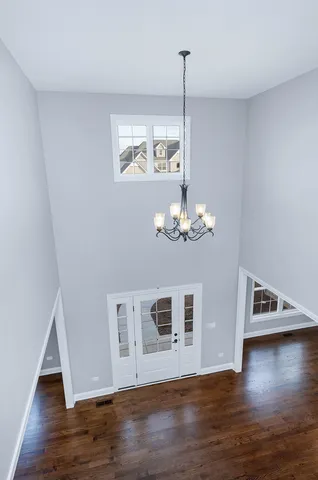 a view of a livingroom with wooden floor staircase and kitchen space