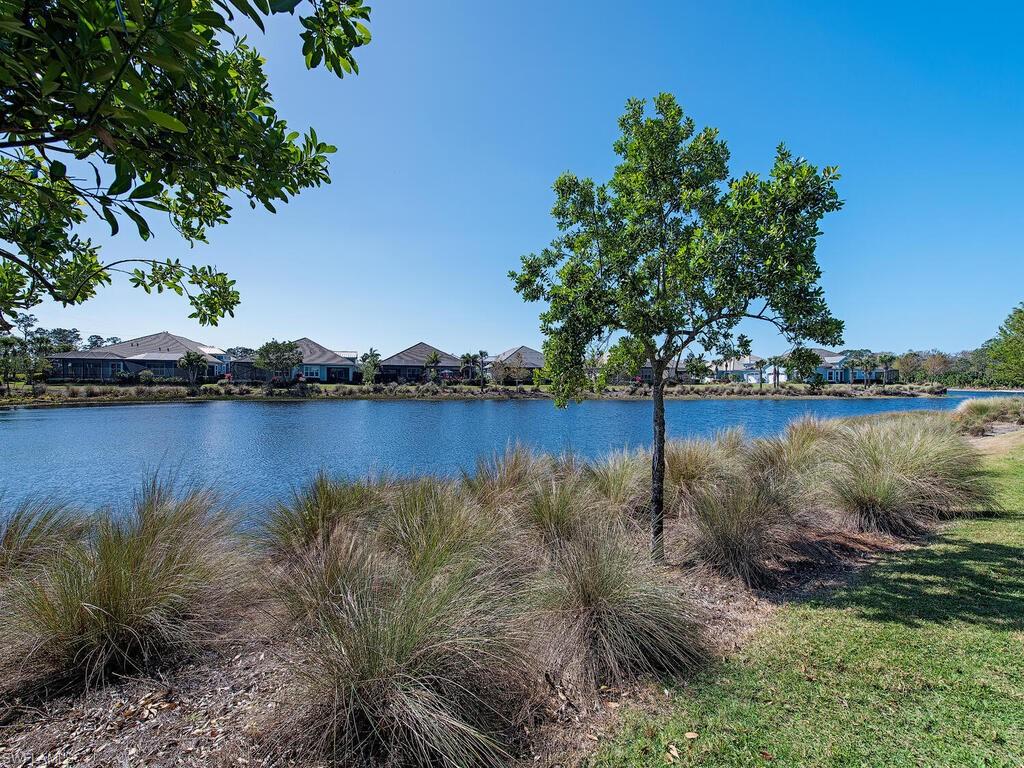 6822 Bequia Way Naples, FL 34113 - Photo 14 of 28 a view of a lake with houses in the back