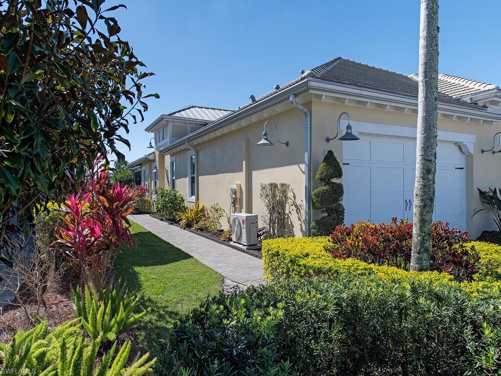 6822 Bequia Way Naples, FL 34113 - Photo 2 of 28 a view of a house with a small yard and potted plants