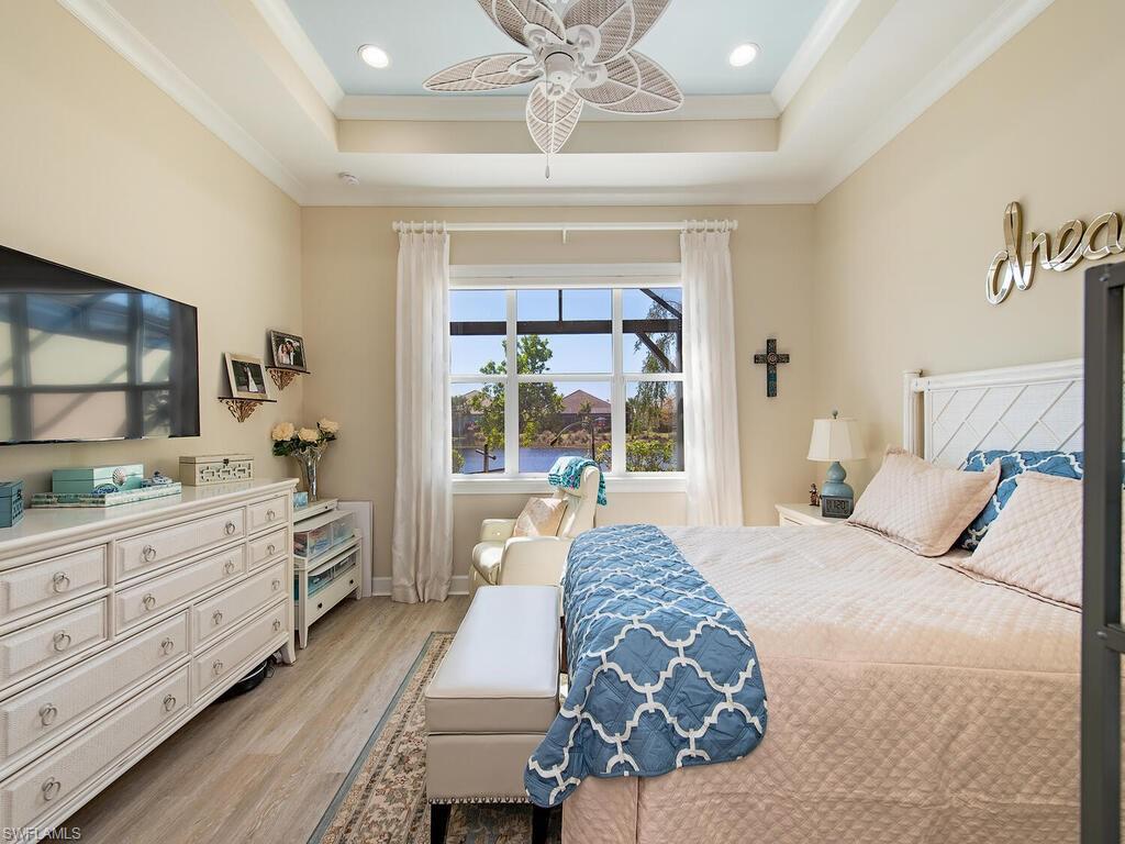 6822 Bequia Way Naples, FL 34113 - Photo 8 of 28 a bedroom with a large bed and a flat tv screen on dresser