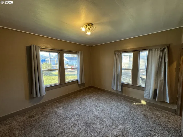 a view of an empty room with a fireplace and a window