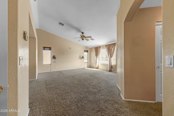 a view of a room with a windows and ceiling fan