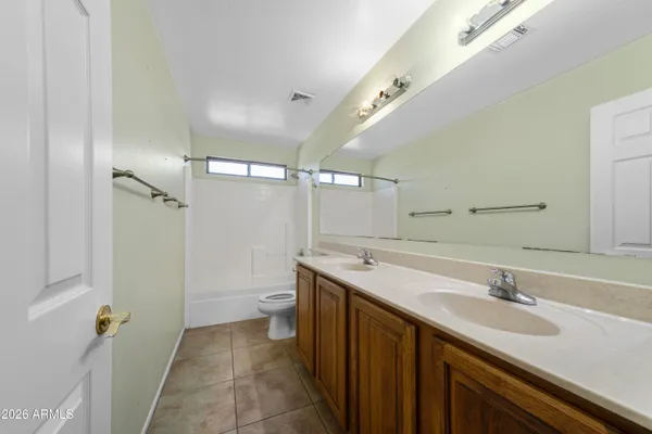 a bathroom with a sink toilet double vanity and shower