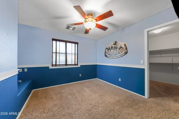 an empty room with window and ceiling fan