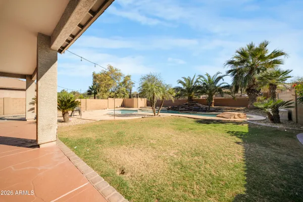 a view of swimming pool with outdoor seating and house in the background