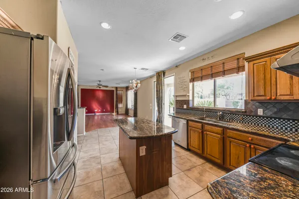 a kitchen with granite countertop a refrigerator and a sink