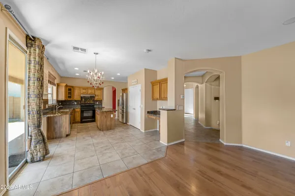 a view of a kitchen with refrigerator and wooden floor