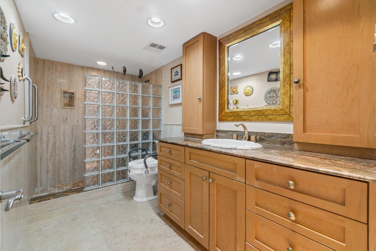 2066 North Ocean Boulevard, Unit 4NW Boca Raton, FL 33431 - Photo 19 of 31 a bathroom with a granite countertop sink a toilet a mirror and shower