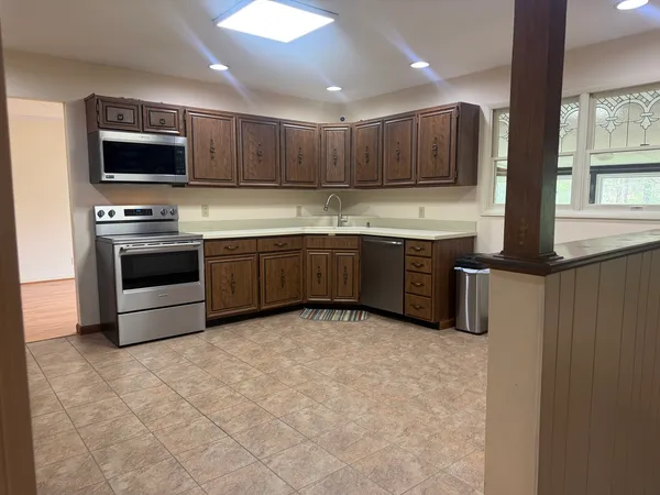 a kitchen with stainless steel appliances granite countertop a refrigerator and a stove top oven
