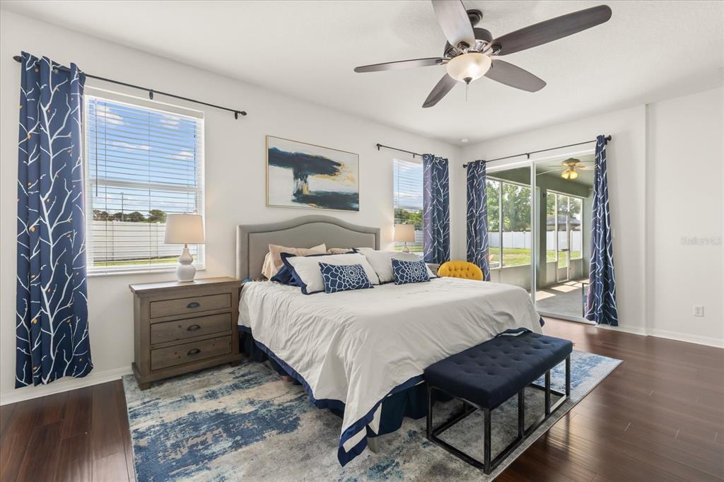 2309 Wolf Ridge Lane Mount Dora, FL 32757 - Photo 23 of 36 a bedroom with a bed a chandelier and a window