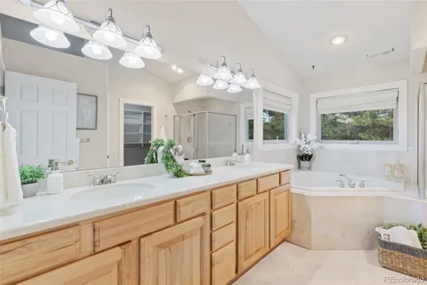 a bathroom with a sink vanity granite tub shower and a mirror