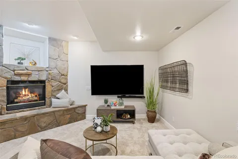 a living room with furniture a fireplace and a flat screen tv