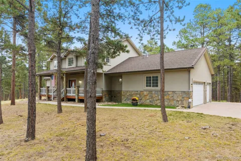 a front view of a house with a yard and trees