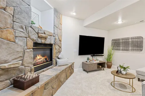 a living room with furniture a flat screen tv and a fireplace
