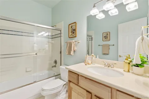 a bathroom with a sink a toilet and a large mirror