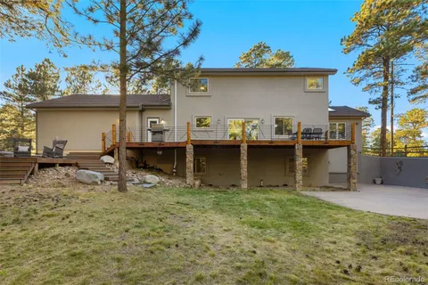 a view of a house with backyard and a tree