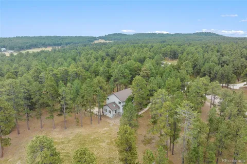 a view of a house with a yard and wooden fence