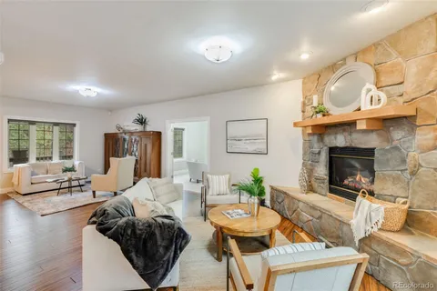 a living room with furniture a fireplace and a large window