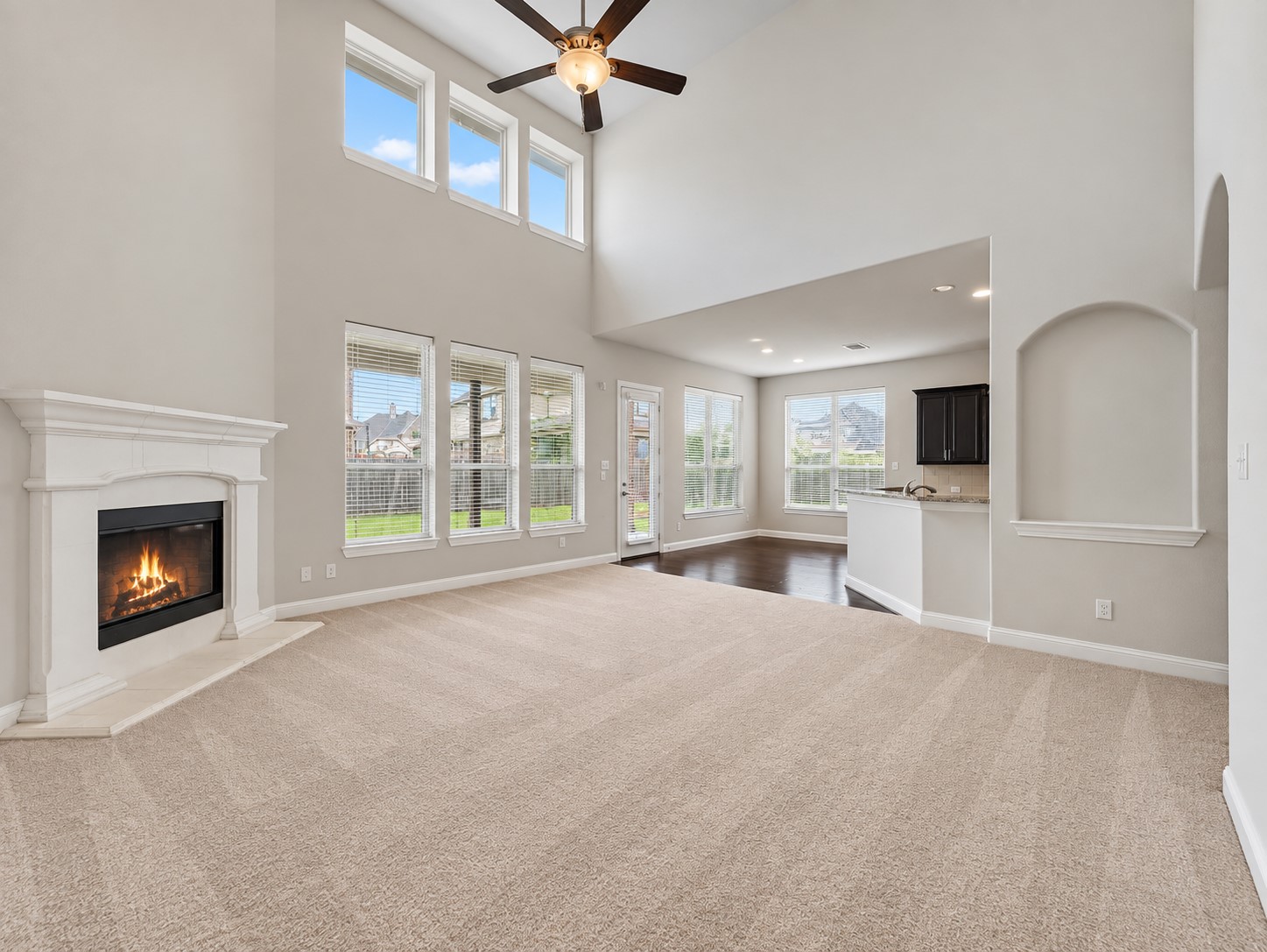 9626 Invergarry Way Tomball, TX 77375 - Photo 10 of 43 Additional view of the two-story living room showcasing the fireplace, high ceilings, upper windows, and wall of windows overlooking the backyard.