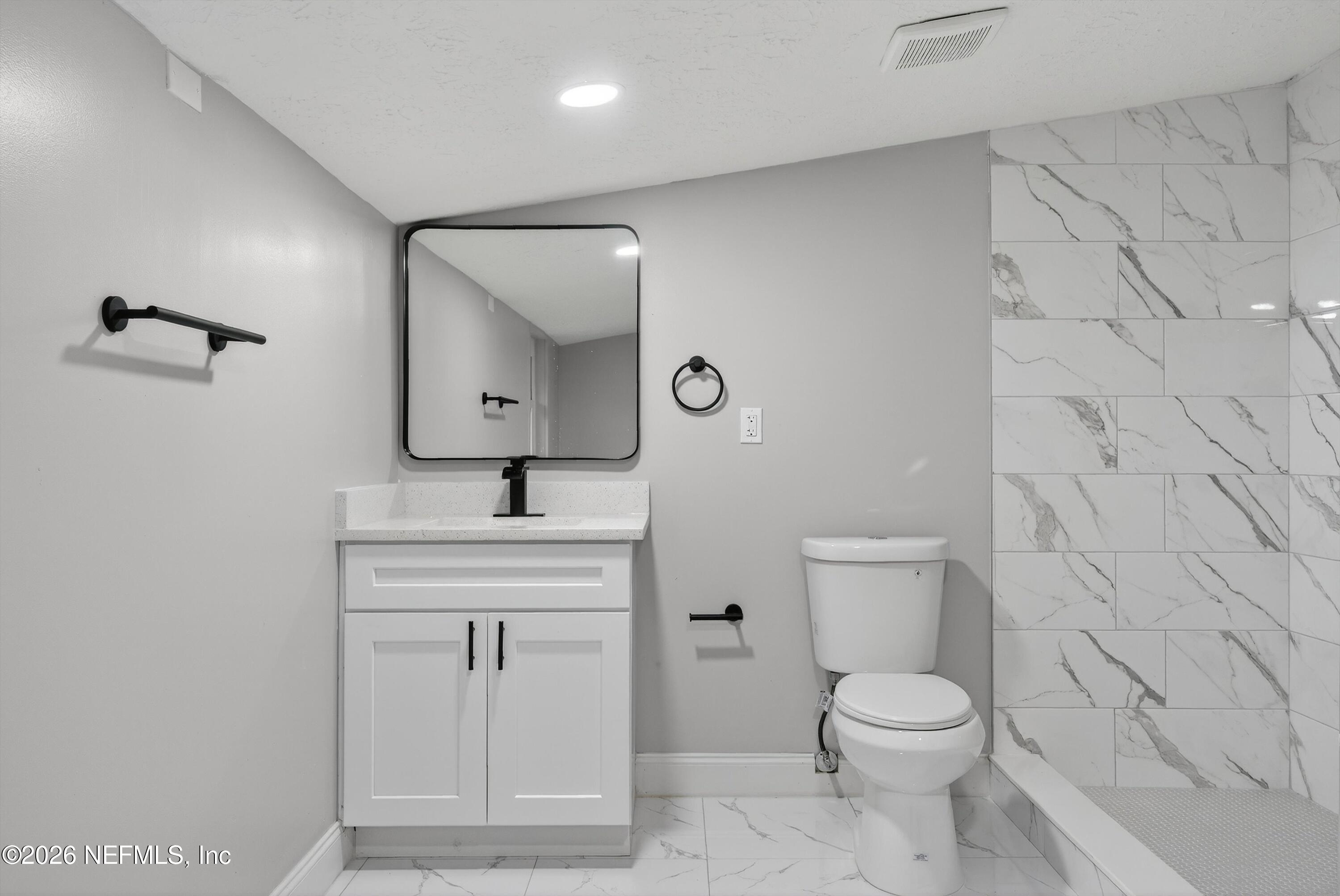 4725 Tango Lane West Jacksonville, FL 32210 - Photo 42 of 54 a bathroom with a toilet a sink a mirror and vanity