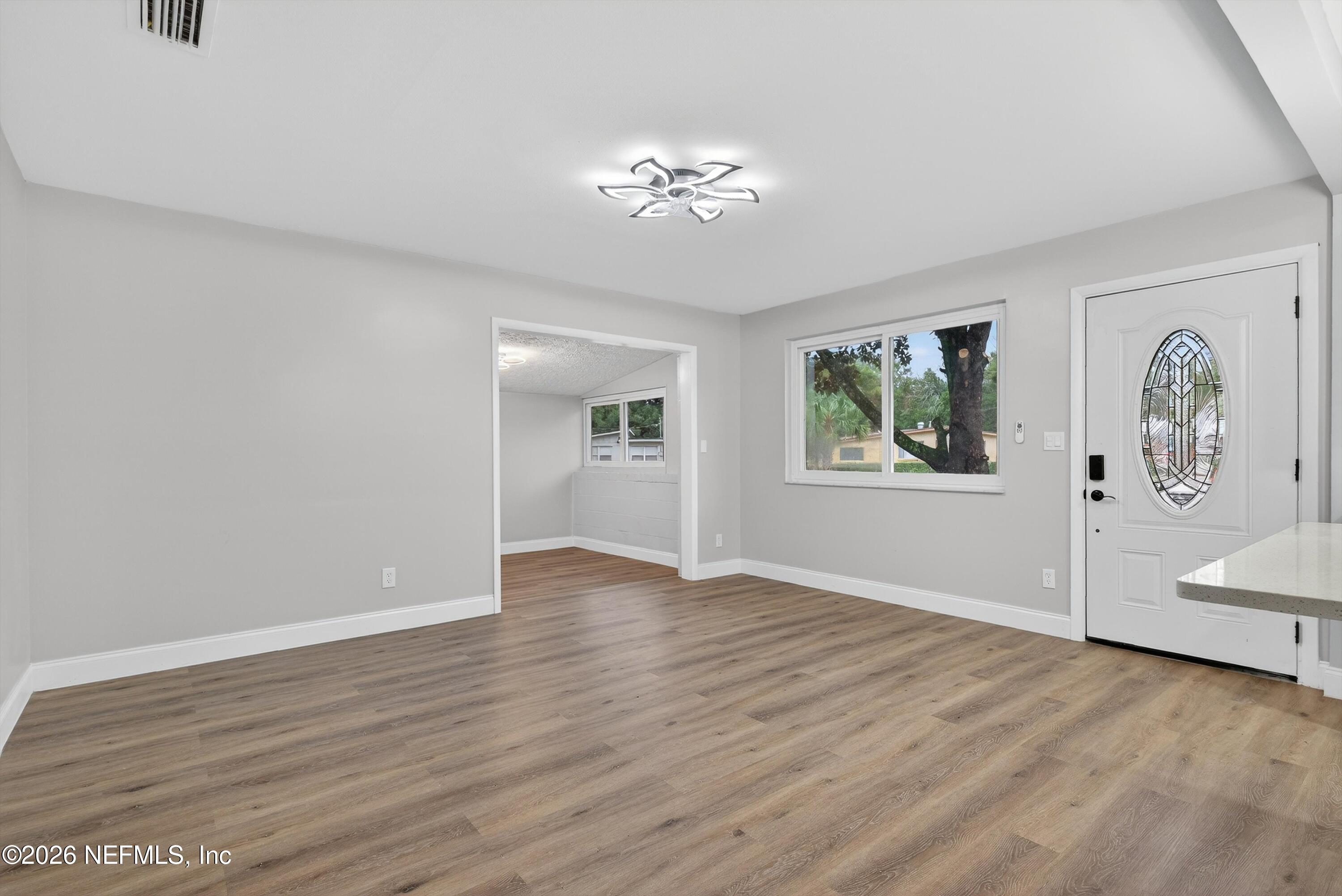 4725 Tango Lane West Jacksonville, FL 32210 - Photo 8 of 54 a view of an empty room with window and wooden floor